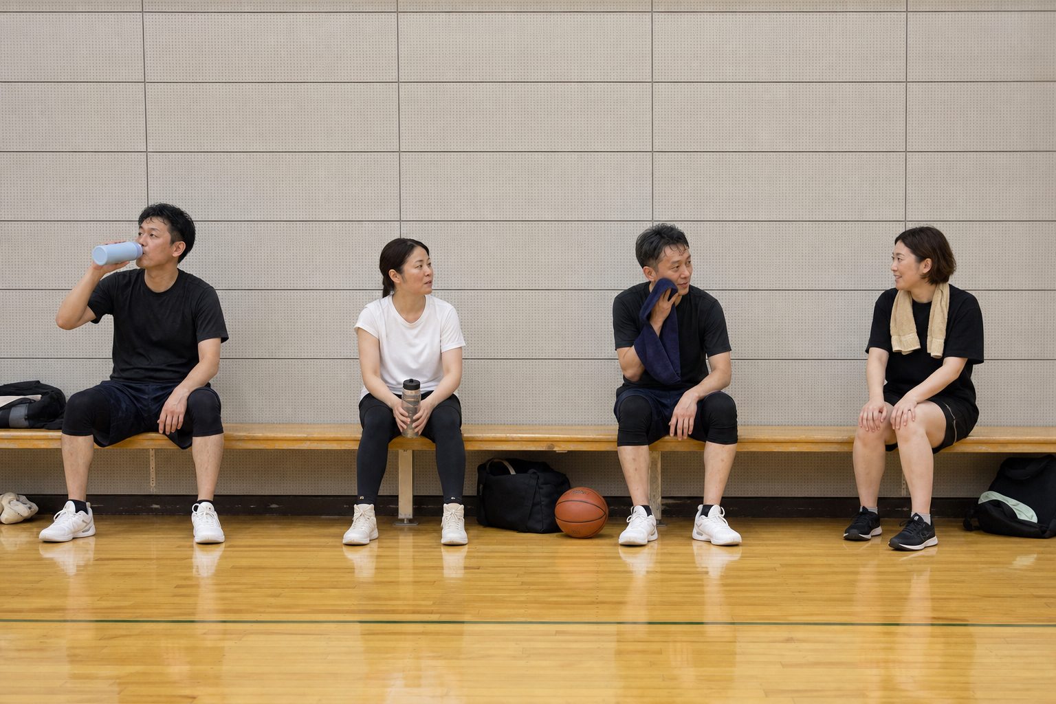 ベンチに座って水分補給と会話をするメンバー